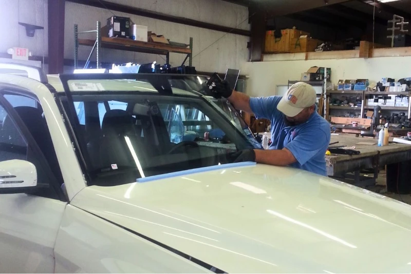texas_glass_and_tinting_employee_installing_a_cars_windshield_1